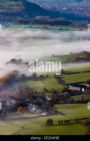 Grüne Felder und landwirtschaftliches Ackerland, bedeckt mit niedrig hängendem Nebel und Nebel. Stockfoto