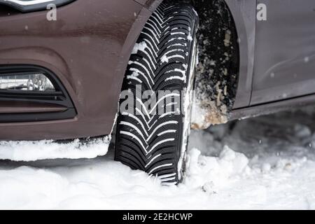 Auto mit Winterreifen in verschneiten Outdoor-Straße, Reifen im Winter auf Schnee, Nahaufnahme Stockfoto