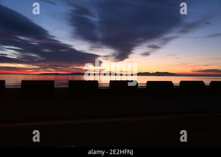 Isle of Arran, Schottland, Großbritannien. Sonnenuntergang über der Insel vom Strand in Ayr. Bekannt als der schlafende Riese aufgrund seiner Umrisse, besonders von der Ayrshire Coast aus gesehen. Stockfoto