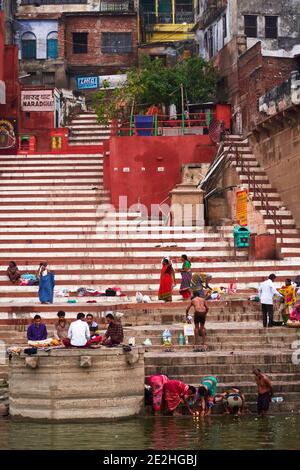 Varanasi (ex-Bénares), Uttar Pradesh, Indien. Zur Zeit der morgendlichen Waschungen, lassen die Männer ihre Kleidung auf den Stufen eines Ghats, um sie selbst zu tauchen Stockfoto