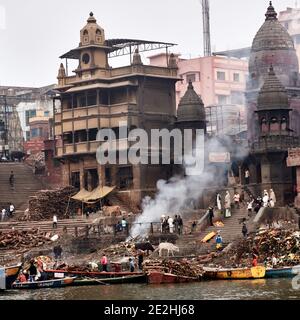 Varanasi, Uttar Pradesh, Indien.EIN toter Körper liegt auf einer Bahre auf den Stufen des Manikarnika-Ghats und wartet darauf, in das heilige Wasser eingetaucht zu werden Stockfoto