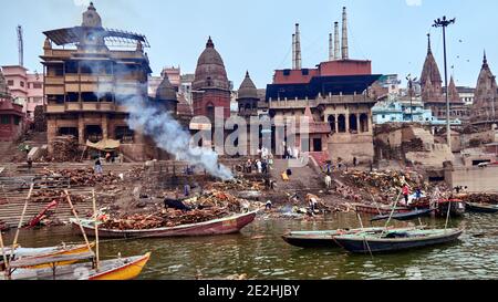 Varanasi, Uttar Pradesh, Indien.EIN toter Körper liegt auf einer Bahre auf den Stufen des Manikarnika-Ghats und wartet darauf, in das heilige Wasser eingetaucht zu werden Stockfoto