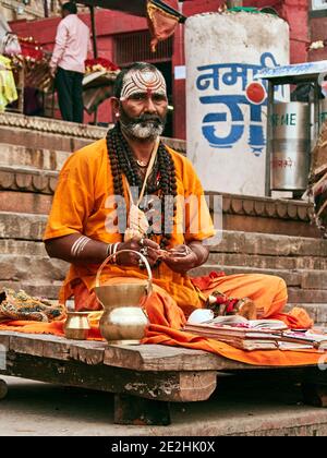 Indien, Uttar Pradesh, Varanasi. Auf dem Dashashwamedh Ghat trifft man viele Weise Männer oder eifrige Anhänger, die mit ihren Gebetsbüchern und ihren reli installiert werden Stockfoto