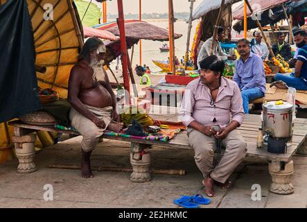 Indien, Uttar Pradesh, Varanasi. Auf dem Dashashwamedh Ghat trifft man viele Weise Männer oder eifrige Anhänger, die mit ihren Gebetsbüchern und ihren reli installiert werden Stockfoto