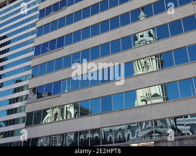 Bild des Philadelphia City Hall, das auf nahe gelegenen Gebäuden reflektiert. Stockfoto