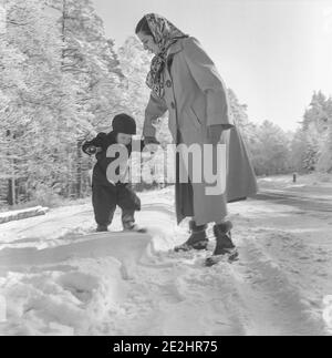 1950s S/W Mutter und kleiner Sohn spielen im Schnee, Deutschland Stockfoto