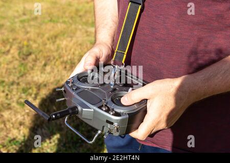 Hände, die einen Sender mit Funkfernbedienung halten. Spielzeug Flugzeug Pilotierung, Outdoor-Aktivitäten Stockfoto