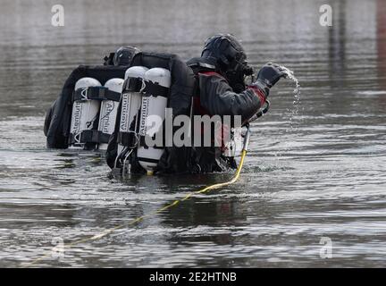 Berlin, Deutschland. Januar 2021. Taucher der Berliner Feuerwehr stehen am Habermannsee. Trotz der winterlichen Kälte haben Taucher der Berliner Feuerwehr ein versunkenes Auto aus einem See geholt. Hobbytaucher hatten das Autowrack am Habermannsee im Kreis Kaulsdorf entdeckt. Quelle: Paul Zinken/dpa-Zentralbild/dpa/Alamy Live News Stockfoto