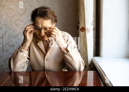 Sehr alte Frau zieht eine Brille an Stockfoto