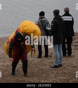 Berlin, Deutschland. Januar 2021. Ein Taucher der Feuerwehr trägt ein Luftkissen am Ufer des Habermannsee. Trotz der winterlichen Kälte haben Taucher der Berliner Feuerwehr ein versunkenes Auto aus einem See geholt. Hobbytaucher hatten das Autowrack am Habermannsee im Kreis Kaulsdorf entdeckt. Quelle: Paul Zinken/dpa-Zentralbild/dpa/Alamy Live News Stockfoto