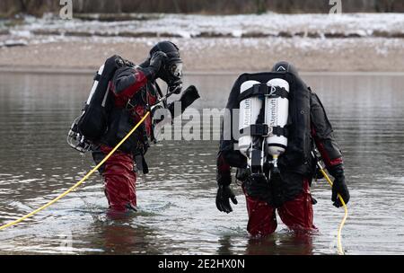 Berlin, Deutschland. Januar 2021. Taucher der Berliner Feuerwehr stehen am Habermannsee. Trotz der winterlichen Kälte haben Taucher der Berliner Feuerwehr ein versunkenes Auto aus einem See geholt. Hobbytaucher hatten das Autowrack am Habermannsee im Kreis Kaulsdorf entdeckt. Quelle: Paul Zinken/dpa-Zentralbild/dpa/Alamy Live News Stockfoto