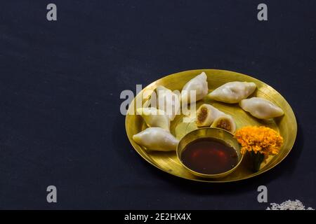 Köstliche bengalische Reismehl Kokosnussknödel während bengali indian Festival von makar sankranti serviert. Foto in schwarzem Hintergrund. Copy Space BA Stockfoto