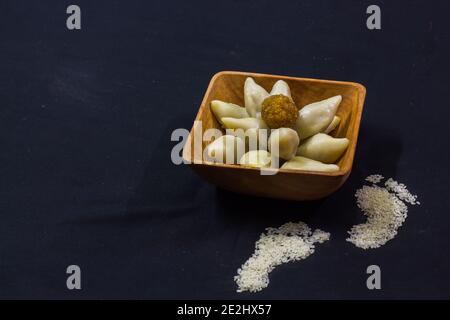 Köstliche bengalische Reismehl Kokosnussknödel während bengali indian Festival von makar sankranti serviert. Foto in schwarzem Hintergrund. Copy Space BA Stockfoto