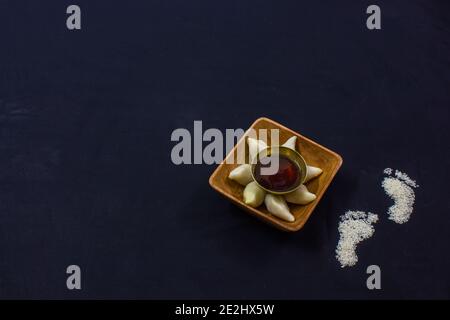 Köstliche bengalische Reismehl Kokosnussknödel während bengali indian Festival von makar sankranti serviert. Foto in schwarzem Hintergrund. Copy Space BA Stockfoto