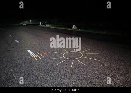 MOTALA, SCHWEDEN - 13. DEZEMBER 2020: Jemand, der während der dunklen Corona-Zeit eine Sonne auf den Asphalt einer Ruhestätte zog. Stockfoto