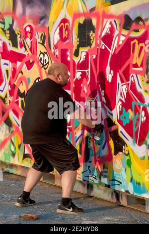 HELSINGBORG, SCHWEDEN - 08. AUGUST 2020: Ein erwachsener Rüde kreiert Graffiti-Kunst im pixlapiren Skatepark in der Stadt. Stockfoto