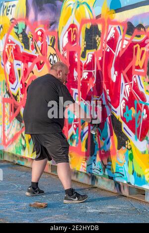 HELSINGBORG, SCHWEDEN - 08. AUGUST 2020: Ein erwachsener Rüde kreiert Graffiti-Kunst im pixlapiren Skatepark in der Stadt. Stockfoto