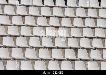 Weißer Kunststoff leere Stadion oder Bühne Stühle in einer Reihe und nummerierte Stufen. Stockfoto