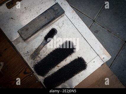 Schuhreinigungsbürsten und Creme eines Schuhreinigers auf der Straße. Stockfoto