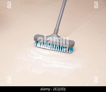 Besen Reinigung keramischen Fliesenboden im Badezimmer Stockfoto