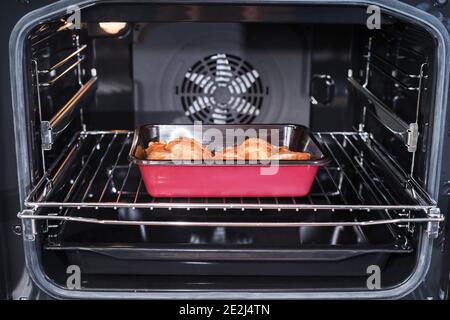 Hähnchenfleisch im Ofen in der Schale. Roher Drumstick im Ofen.Hähnchenschenkel im Ofen gebacken. Stockfoto