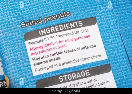 Nahaufnahme von Lebensmittelzutaten auf Plastikfolie von ASDA gesalzene Erdnüsse Beutel. Warnung vor Lebensmittelallergien auf Kunststoffverpackungen, Zutatenliste. Stockfoto