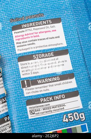 Nahaufnahme von Lebensmittelzutaten auf einer weichen Plastikverpackung des ASDA-Beutels mit gesalzenen Erdnüssen. Warnung vor Lebensmittelallergien auf Kunststoffverpackungen. Stockfoto