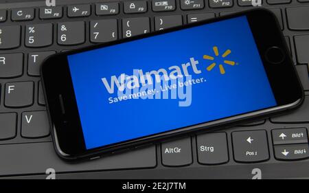 Viersen, Deutschland - 9. Mai. 2020: Nahaufnahme des Mobiltelefons auf Laptop-Tastatur mit Logo-Schriftzug von uns amerikanischen Supermarkt-Firma Walmart Stockfoto