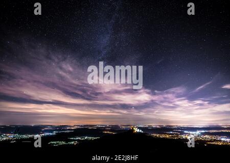 Nachtaufnahme der Sterne und Wolken Himmel aus dem Zeller Horn in Bisingen Hechingen mit Blick auf den Ritter Burg Hohenzollern über das weite Land Stockfoto