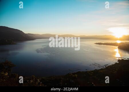 Sonnenaufgang am Atitlán See die Sonne geht hinter den Bergen auf - Sonnenaufgangslandschaft am See in Guatemala Stockfoto