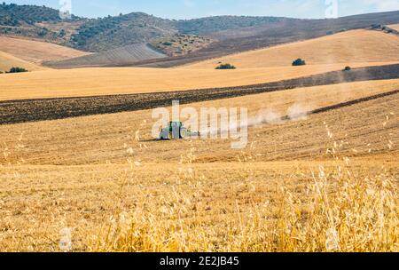 Landwirt im Traktor Pflügen Feld in Vorbereitung für die Pflanzung. Provinz Malaga, Andalusien, Spanien. Stockfoto