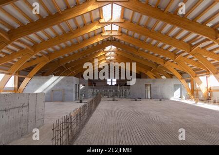 Nahaufnahme der Verbindung von Holzbalken. Holzdachrahmen im Bau. Das Innere eines großen Industriegebäudes oder Fabrik mit Holz Stockfoto
