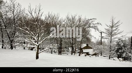 Bedeckt das Bauernhaus, Tiefschnee nach ganztägig Schneefall auf Moorland Kleinbetrieb in Nidderdale. Stockfoto