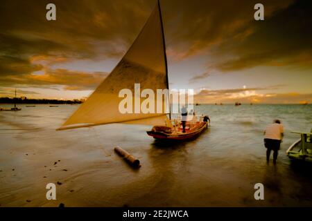 Sonnenuntergang und touristische Boote auf einem Strand in Maceió, Brasilien Stockfoto