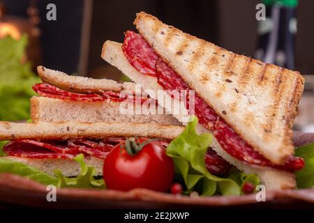 Heep von Sandwiches getoastetes Brot цшер Salami auf Holztisch. Fastfood ungesunde Konzept. Stockfoto