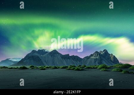 Aurora Borealis Nordlichter über schwarzen Sanddünen und grasbewachsenen Unebenheiten in der Nähe der berühmten Stokksnes Berge auf Vestrahorn Kap, Island. Landschaftsfotografie. Mit freundlicher Genehmigung der NASA. Fotocollage Stockfoto