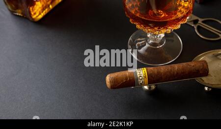 Athen Griechenland, 30. Dezember 2020. Cohiba Cigar, kubanische Premium-Qualität robusto und Alkoholbrand oder Whiskey auf schwarzem Tisch, Kopierraum. Rauchen und d Stockfoto