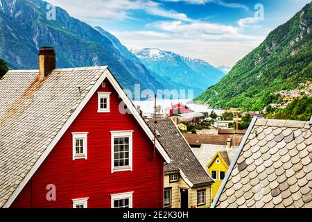 Typische norwegische Häuser in der Nähe von Fjord und schneebedeckten Bergen. Norwegen, Europa. Landschaftsfotografie Stockfoto