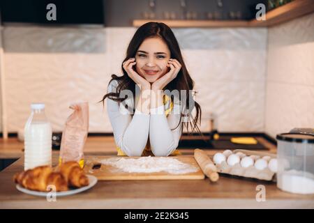 Junge Hausfrau Kochen Pie Cookies Kuchen. Hübsche Frau backt in der Küche Stockfoto