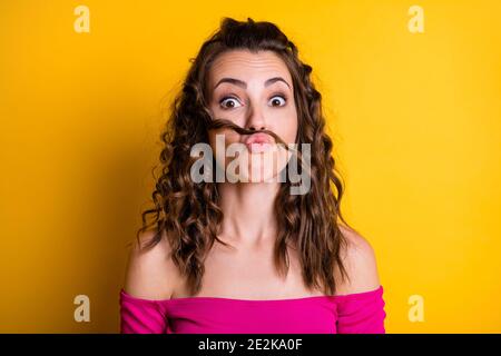 Foto-Porträt von Mädchen, die gefälschte Schnurrbart pouting trägt rosa Crop-top isoliert auf lebhaft gelben Hintergrund Stockfoto