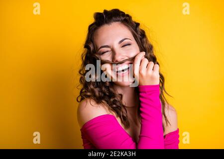 Foto-Porträt von Brünette Mädchen machen gefälschte Schnurrbart mit einem Curl halten mit Hand tragen fuchsia crop-top isoliert auf lebhaft Gelb Stockfoto