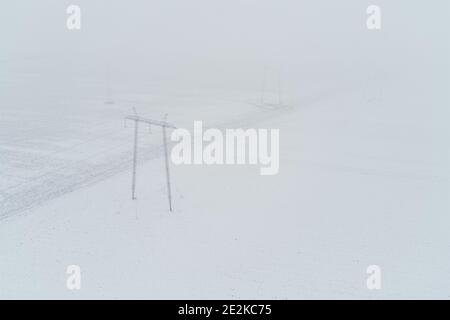 Luftaufnahme der Strommasten im Wintermorgen von der Drohne Pov Stockfoto