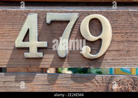 Hausnummernschild 479 auf einem Holzzaun. Hausnummer. Adressnummer. Stockfoto