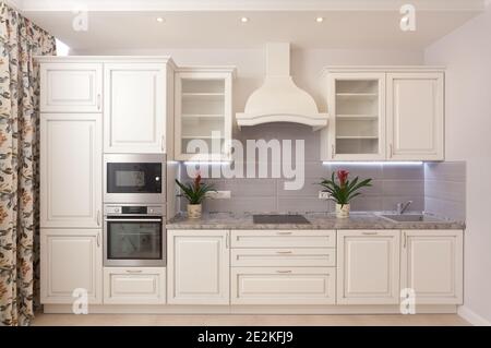 Foto der Theke im epmty minimalistischen Hintergrund, Küche mit Geräten und Blumen auf dem Tisch, niemand, mit Kopierraum, horizontal Stockfoto
