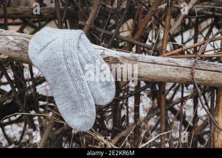Ein Paar graue handgestrickte Socken auf einem dunklen rustikalen Hintergrund. Natürliche Farben. Stockfoto