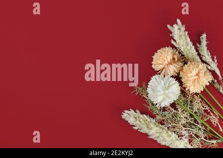 Blumenstrauß mit Pampas Gras und Dahlia Blumen in der Ecke Dunkelroter Hintergrund Stockfoto