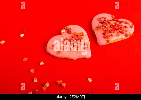 Zwei Kekse Rotes Herz für valentinstag auf rotem Hintergrund geformt. Draufsicht. Leerzeichen für Text. Leckerbissen Stockfoto