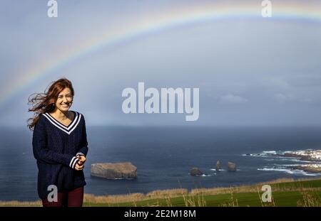 Junge lächelnde Frau unter Regenbogen, Mosteiros Dorf, Azoren Inseln. Stockfoto