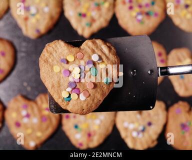 80ER JAHRE HERZFÖRMIGE GEBACKENE PLÄTZCHEN MIT ZUCKER DOT BESTREUT DESSERT - KF19139 DAS001 HARS ALTMODISCH Stockfoto