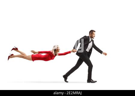 Geschäftsmann läuft und zieht eine fliegende Frau in einem roten Kleid isoliert auf weißem Hintergrund Stockfoto